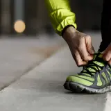 Läufer schnürt seine Laufschuhe. Die perfekte Laufschuhe Passform ist entscheidend für Komfort und Leistung.