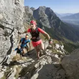 Trailrunner meistern den anspruchsvollen Kaiserkrone Trail, gesichert durch Stahlseile, mit atemberaubendem Blick ins Tal.