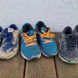 Abgelaufene Laufschuhe erkennt man an starker Abnutzung, Schmutz und ausgeblichenen Farben. Diese Schuhe haben viele Kilometer hinter sich.