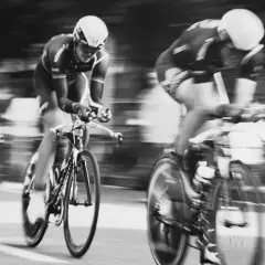 Drei Radfahrer in voller Fahrt, ein Beispiel dafür, wie funktioniert die Tour de France. Die Bewegung ist durch die Unschärfe spürbar.
