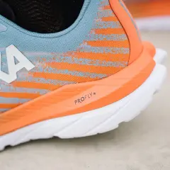 Hoka Laufschuh in Blau und Orange, bereit für mach 5. Die PROFLY+ Sohle verspricht Geschwindigkeit.