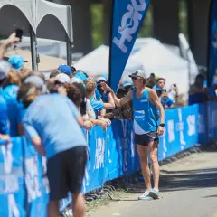 Jim Walmsley gibt Fans einen High-Five. Er trägt ein blaues Laufshirt mit der Aufschrift "WALMSLEY".