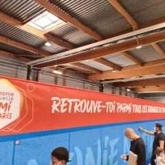 Harmonie Mutuelle SEMI DE PARIS Banner. Menschen stehen vor einer Wand mit Namen, die für den Lauf des SEMI DE PARIS werben.