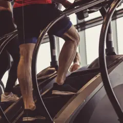 Beine trainieren auf einem Stairmaster im Fitnessstudio.