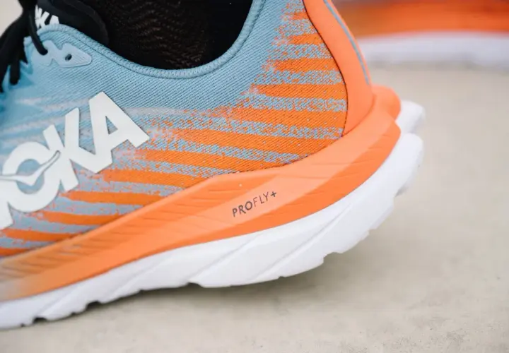 Hoka Laufschuh in Blau und Orange, bereit für mach 5. Die PROFLY+ Sohle verspricht Geschwindigkeit.