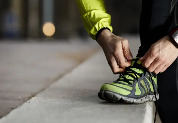 Läufer schnürt seine Laufschuhe. Die perfekte Laufschuhe Passform ist entscheidend für Komfort und Leistung.