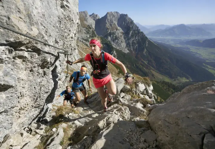 Trailrunner meistern den anspruchsvollen Kaiserkrone Trail, gesichert durch Stahlseile, mit atemberaubendem Blick ins Tal.