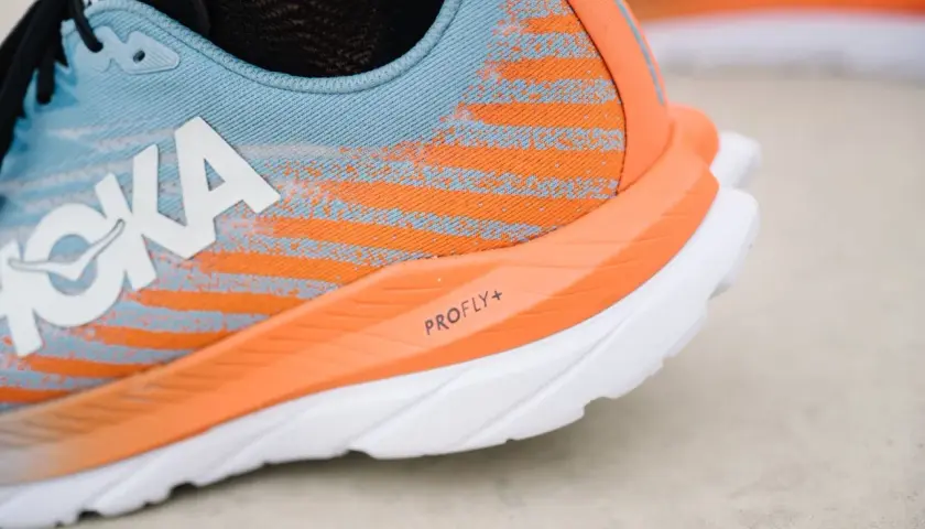 Hoka Laufschuh in Blau und Orange, bereit für mach 5. Die PROFLY+ Sohle verspricht Geschwindigkeit.