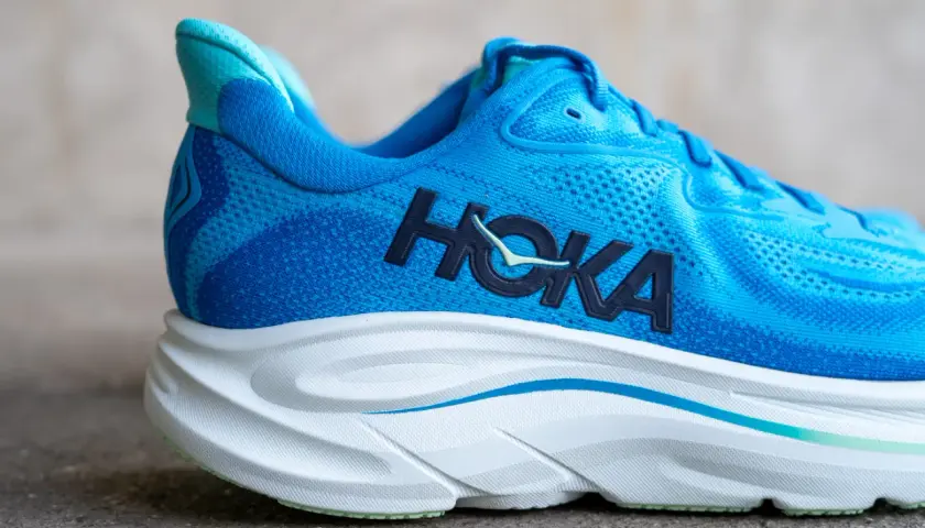 Blauer Hoka Laufschuh mit markantem Logo und dicker, weißer Sohle.