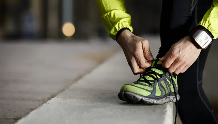 Läufer schnürt seine Laufschuhe. Die perfekte Laufschuhe Passform ist entscheidend für Komfort und Leistung.