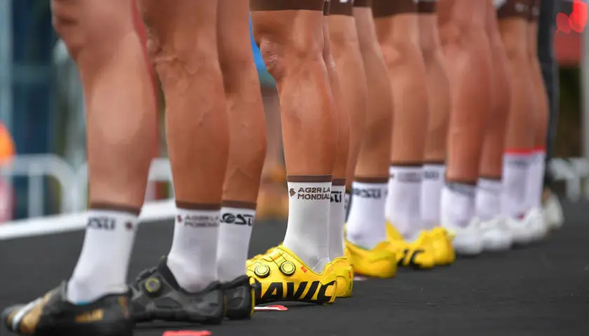 Reihen von Rennrad-Beinen in Radhosen und Socken, bereit für das Rennen.