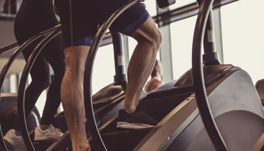Beine trainieren auf einem Stairmaster im Fitnessstudio.