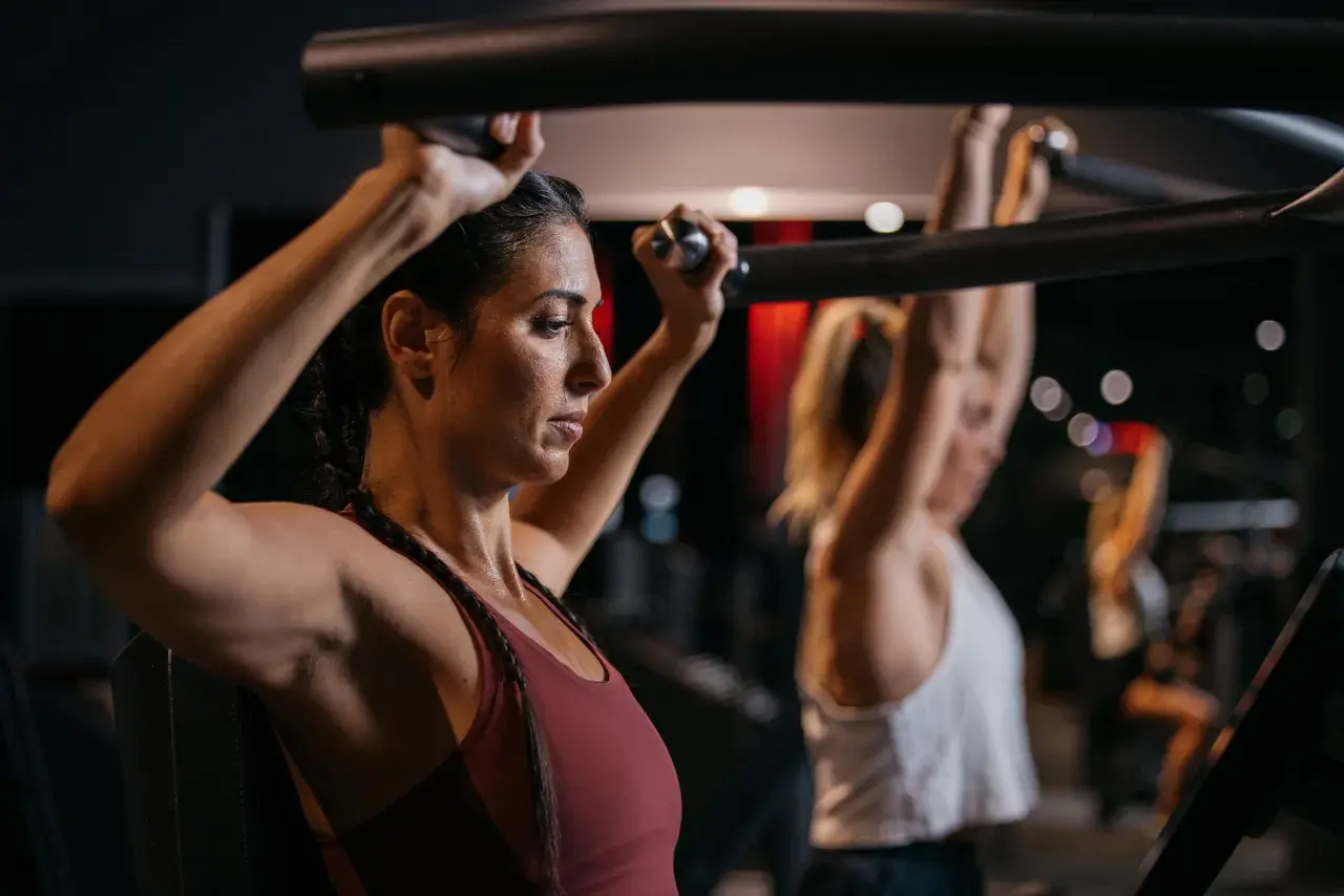 Frau trainiert Schultern im Fitnessstudio, Teil eines Bodybuilding 5er Splits.