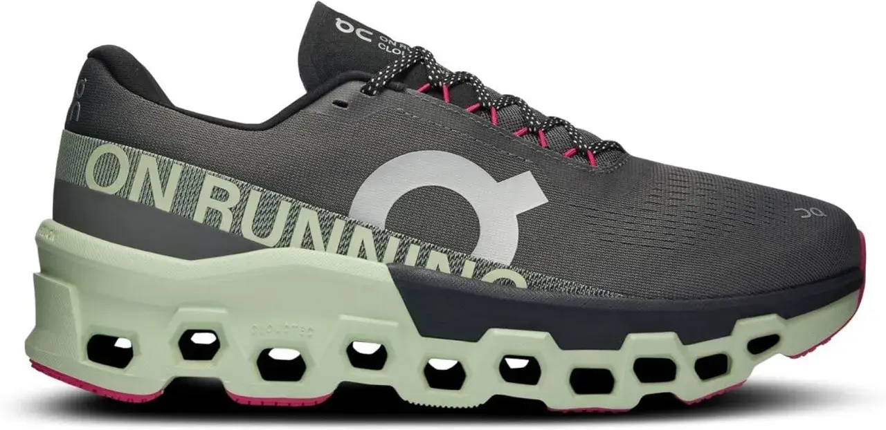 Grauer Herren-Laufschuh "Cloudmonster 2" mit hellgrüner Sohle und pinken Akzenten. "ON RUNNING" Schriftzug.