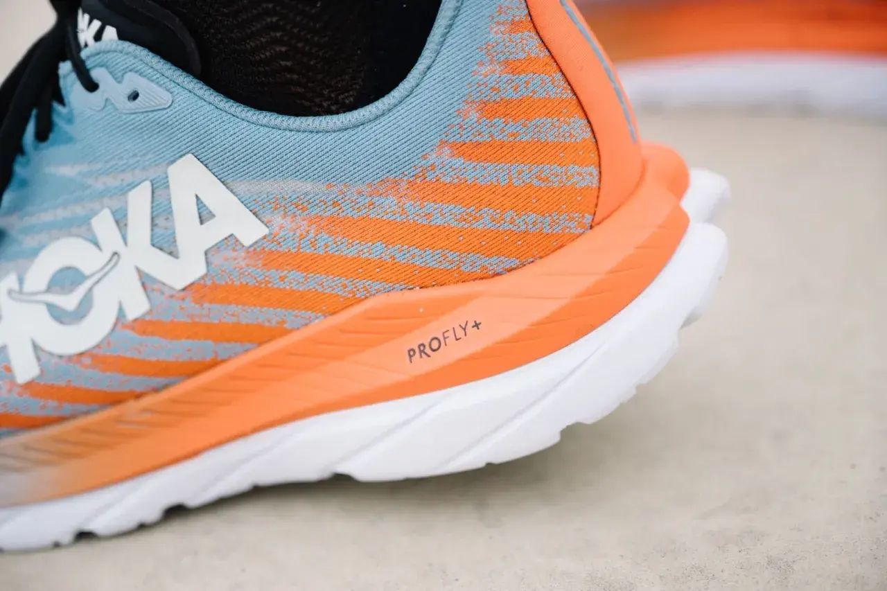 Hoka Laufschuh in Blau und Orange, bereit für mach 5. Die PROFLY+ Sohle verspricht Geschwindigkeit.