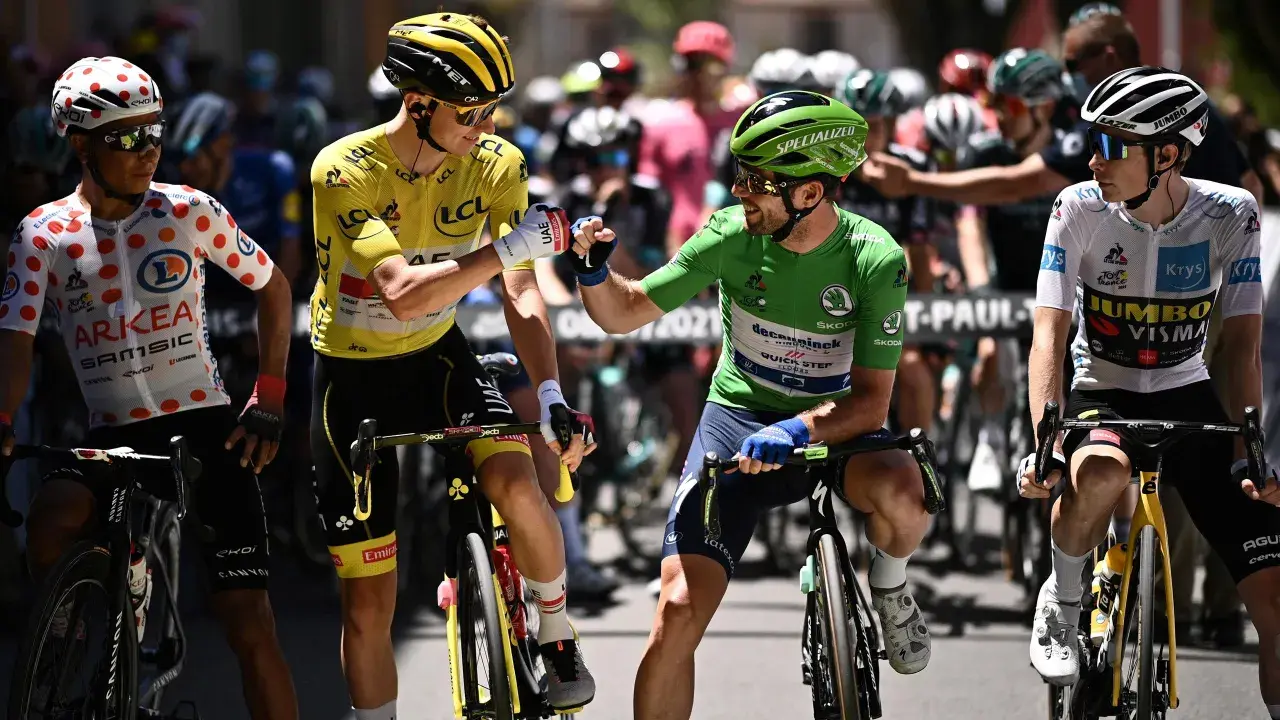 Radfahrer mit gelbem Trikot und grünen Trikot stoßen Fäuste. Ein Radfahrer im gepunkteten Trikot und einer im weißen Trikot stehen daneben. Ein Moment der Anerkennung beim Tour de France Gesamt.