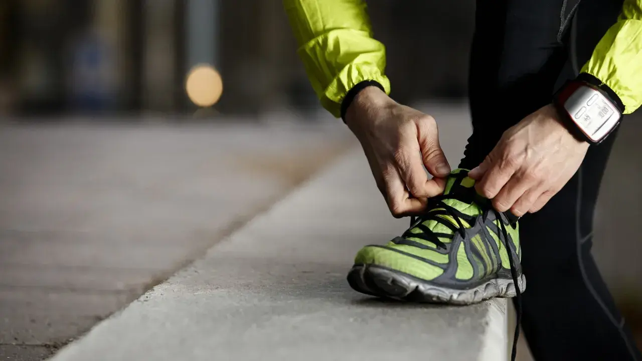 Läufer schnürt seine Laufschuhe. Die perfekte Laufschuhe Passform ist entscheidend für Komfort und Leistung.