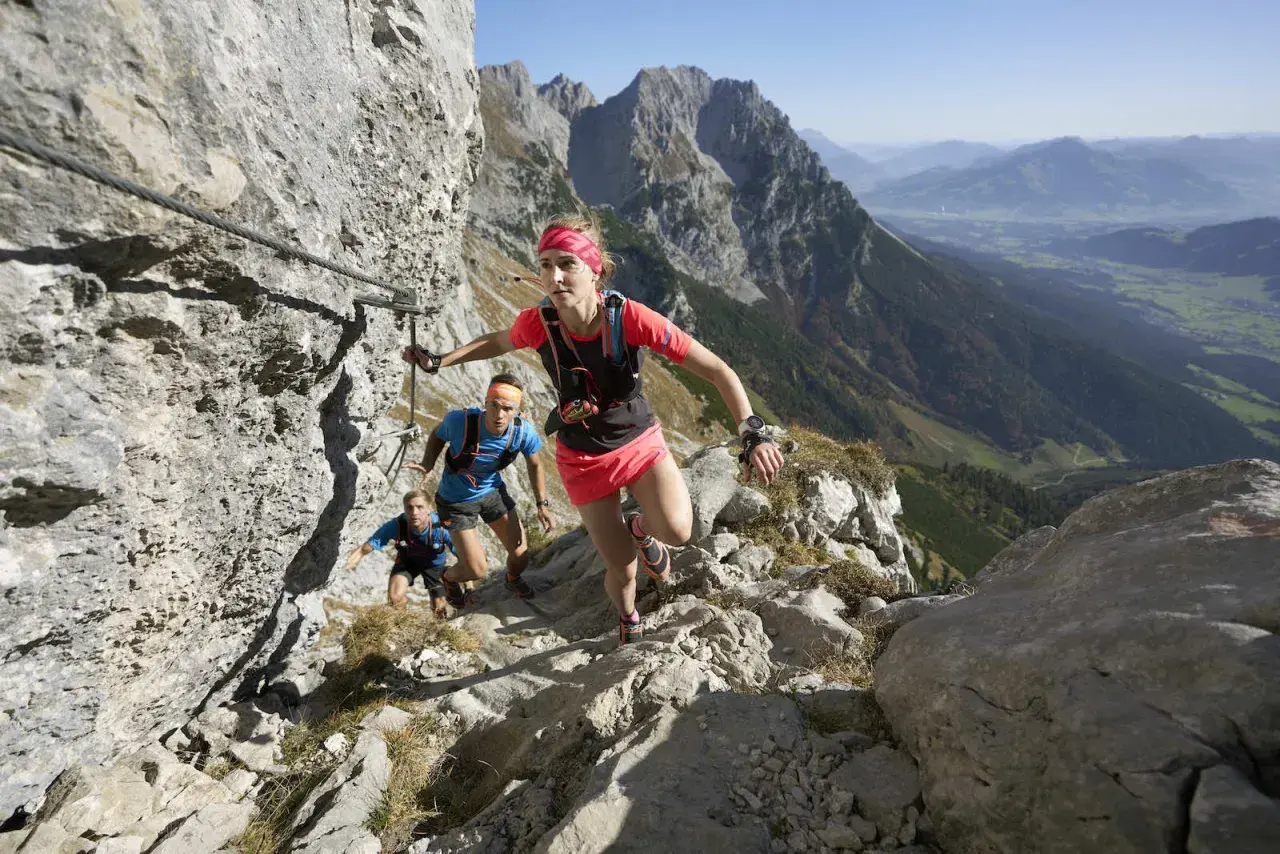 Trailrunner meistern den anspruchsvollen Kaiserkrone Trail, gesichert durch Stahlseile, mit atemberaubendem Blick ins Tal.