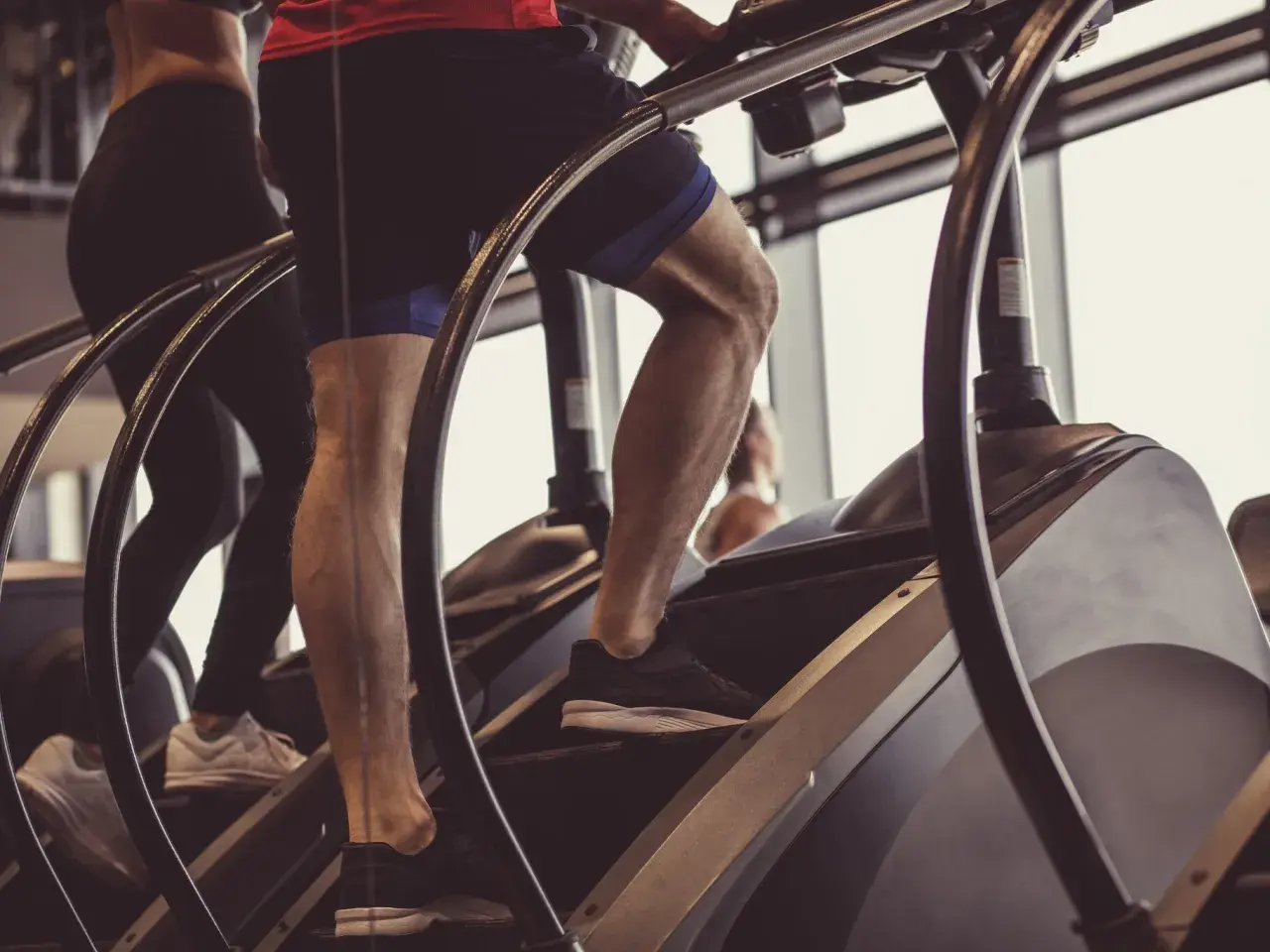 Beine trainieren auf einem Stairmaster im Fitnessstudio.