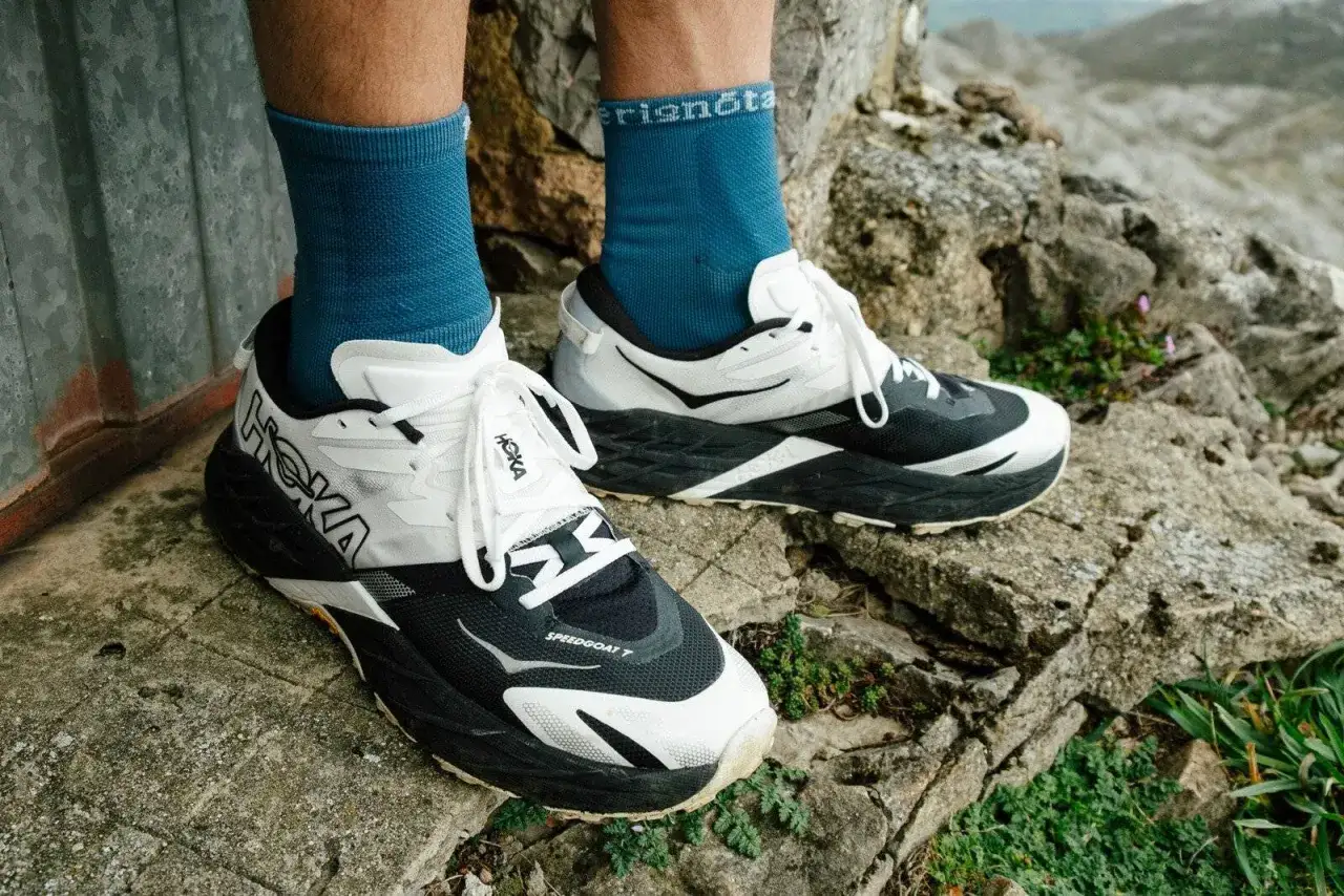 Hoka Speedgoat 7 Trailrunning-Schuhe in Schwarz und Wei&szlig;, bereit f&uuml;r jedes Abenteuer auf felsigem Untergrund.