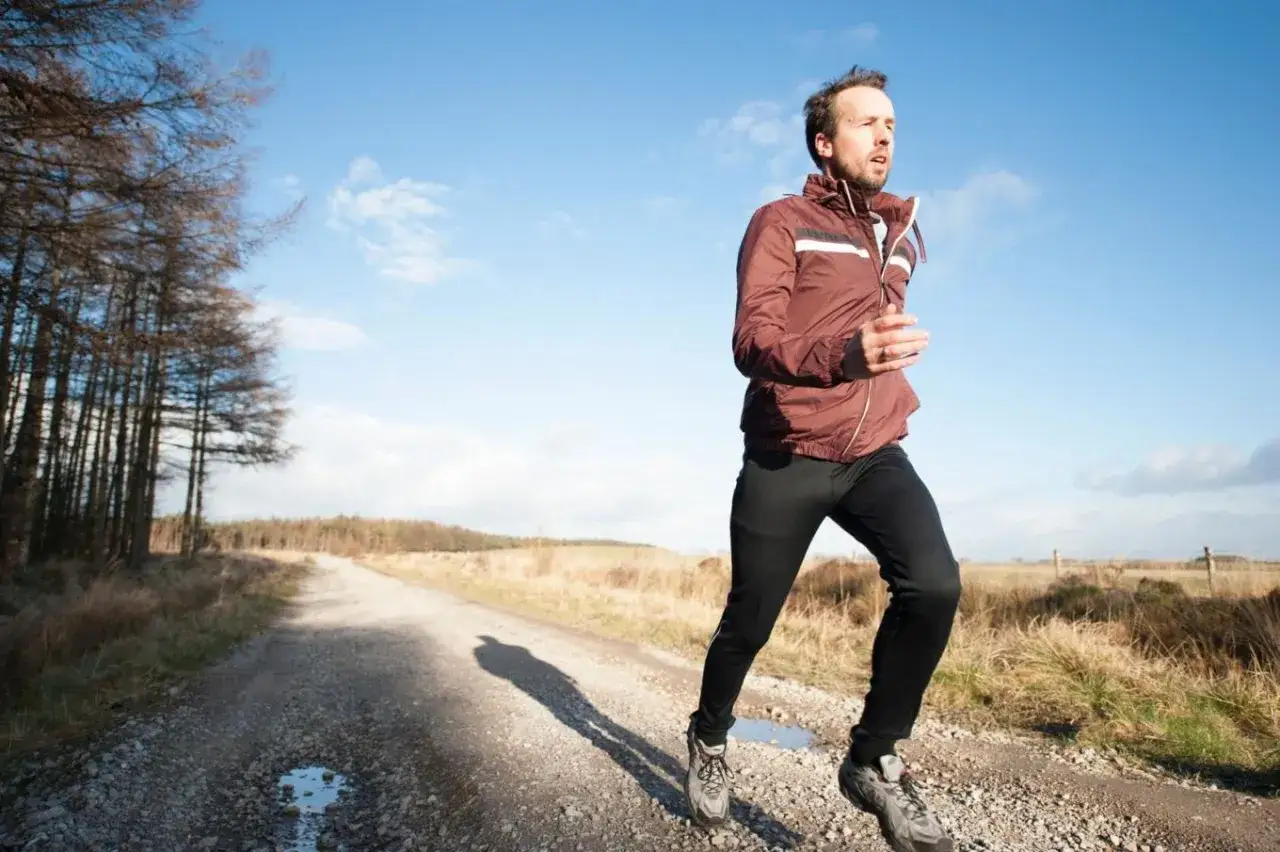 Mann joggt bei 10 Grad im Freien. Die richtige Kleidung zum Joggen bei k&uuml;hlem Wetter ist wichtig.