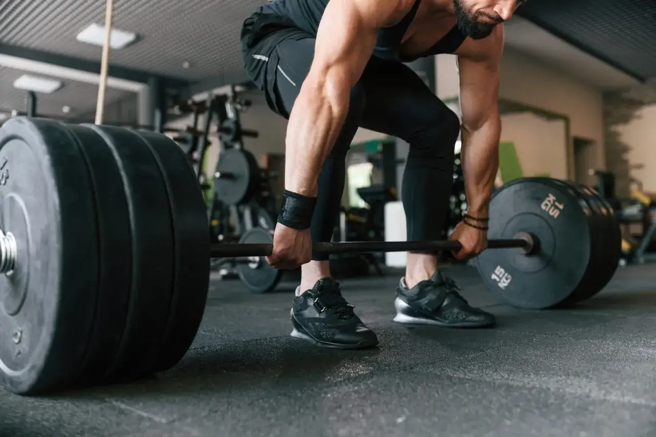 Mann bereitet sich auf einen schweren Deadlift vor, um seine Maximalkraft zu trainieren.