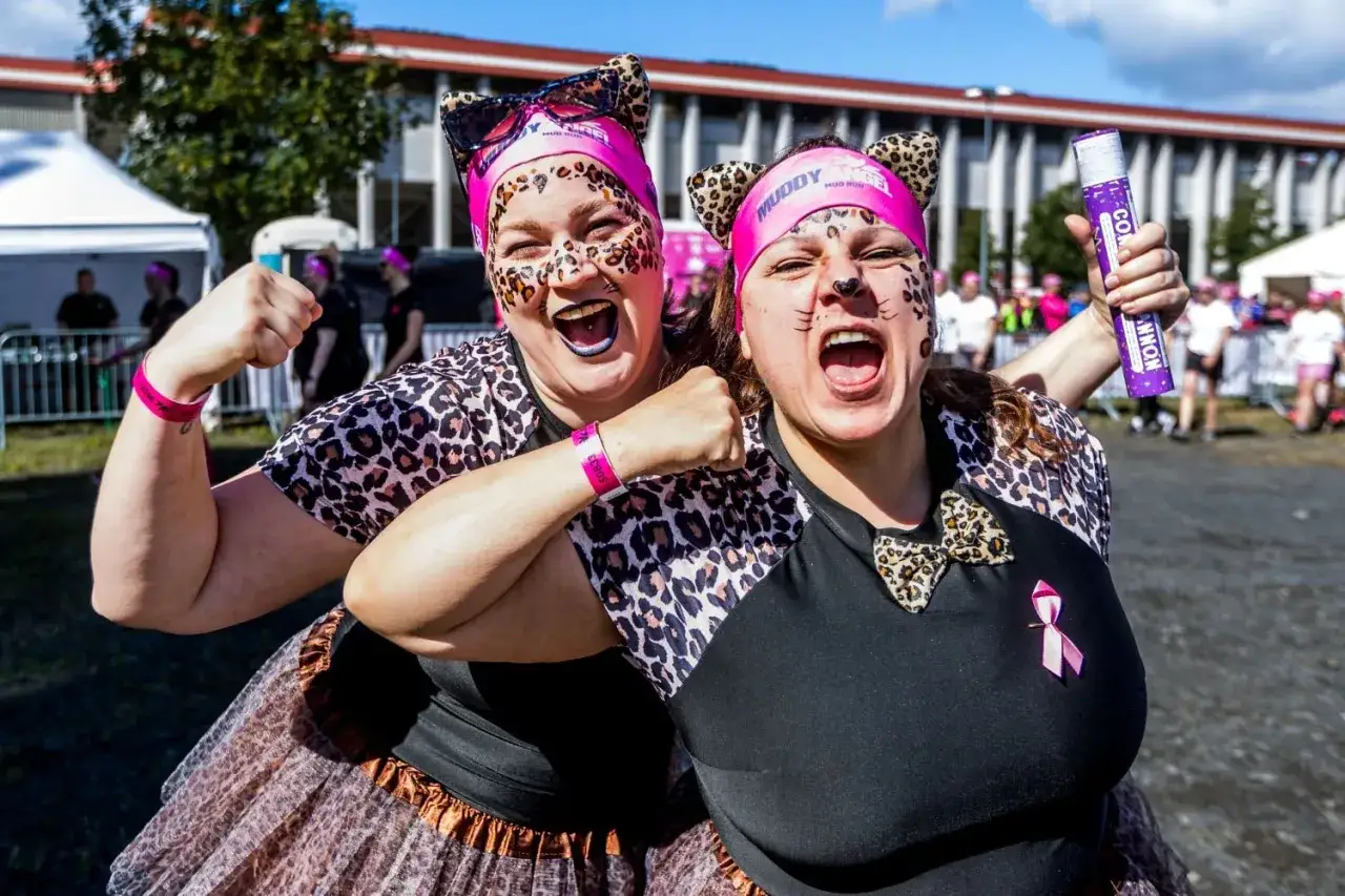 Zwei Frauen mit Leoparden-Make-up und Katzenohren jubeln beim Muddy Angel Run in Offenbach.