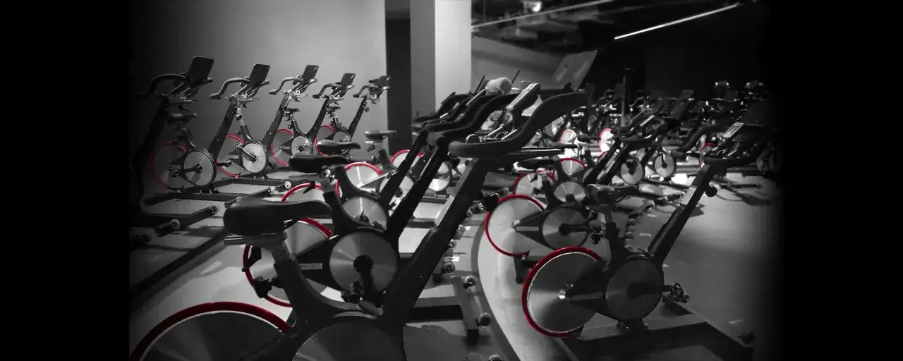 Reihe von Spinning-R&auml;dern mit roten Akzenten, bereit f&uuml;r ein intensives Training.