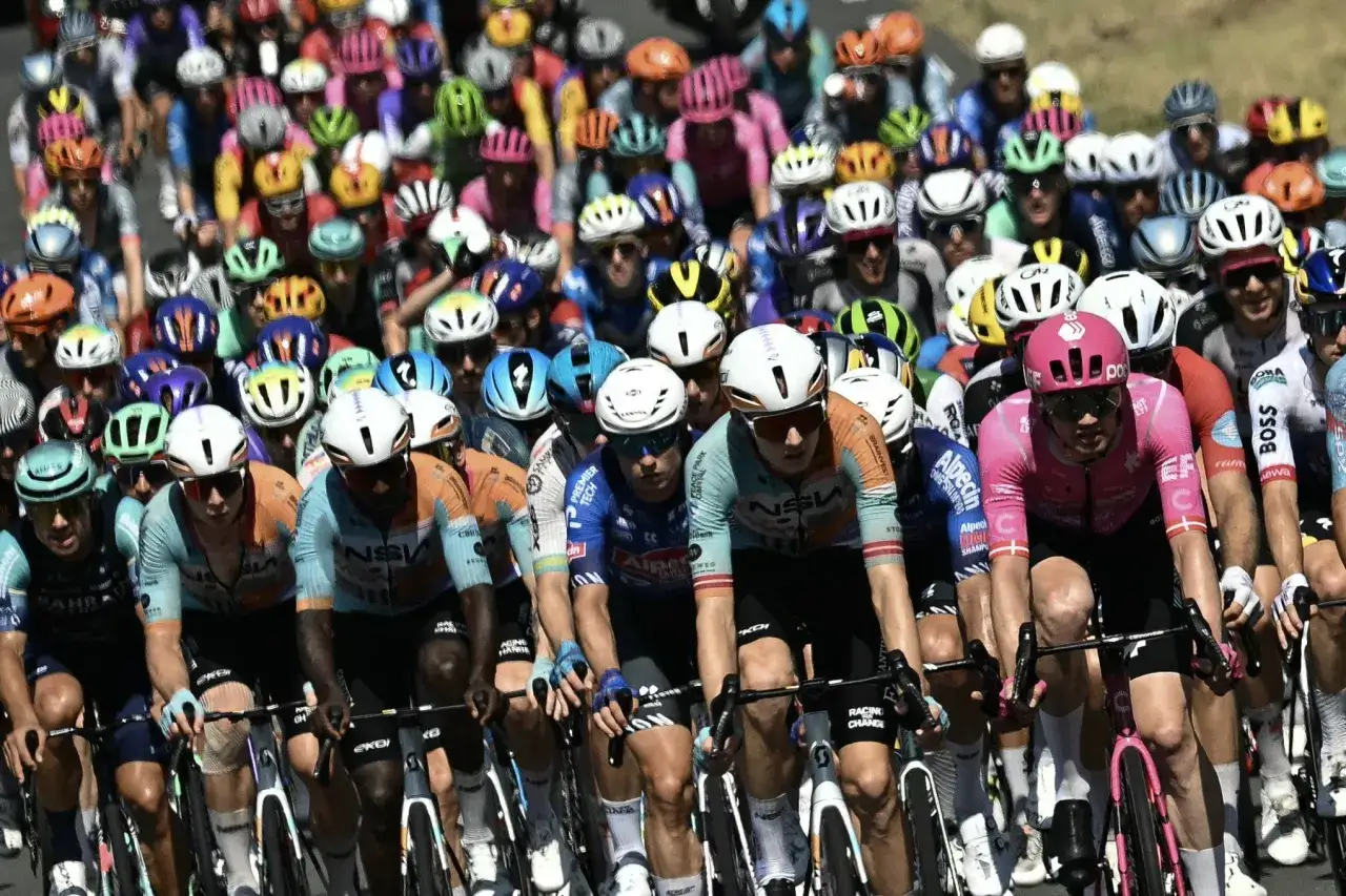 Ein Peloton von Radfahrern in bunten Trikots k&auml;mpft im Radsport um die F&uuml;hrung.