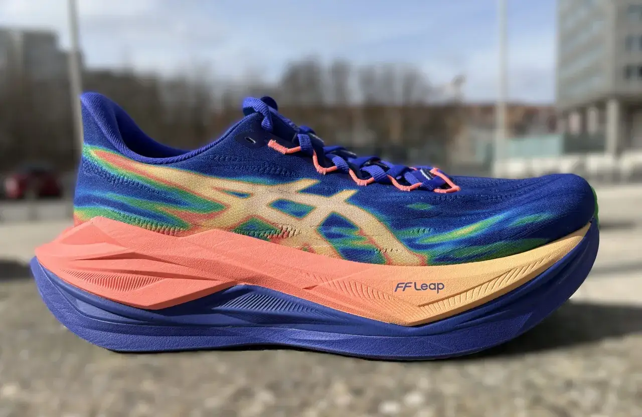 Blauer Laufschuh mit Regenbogenmuster und orangefarbener Sohle, bereit f&uuml;r einen superblast 3.